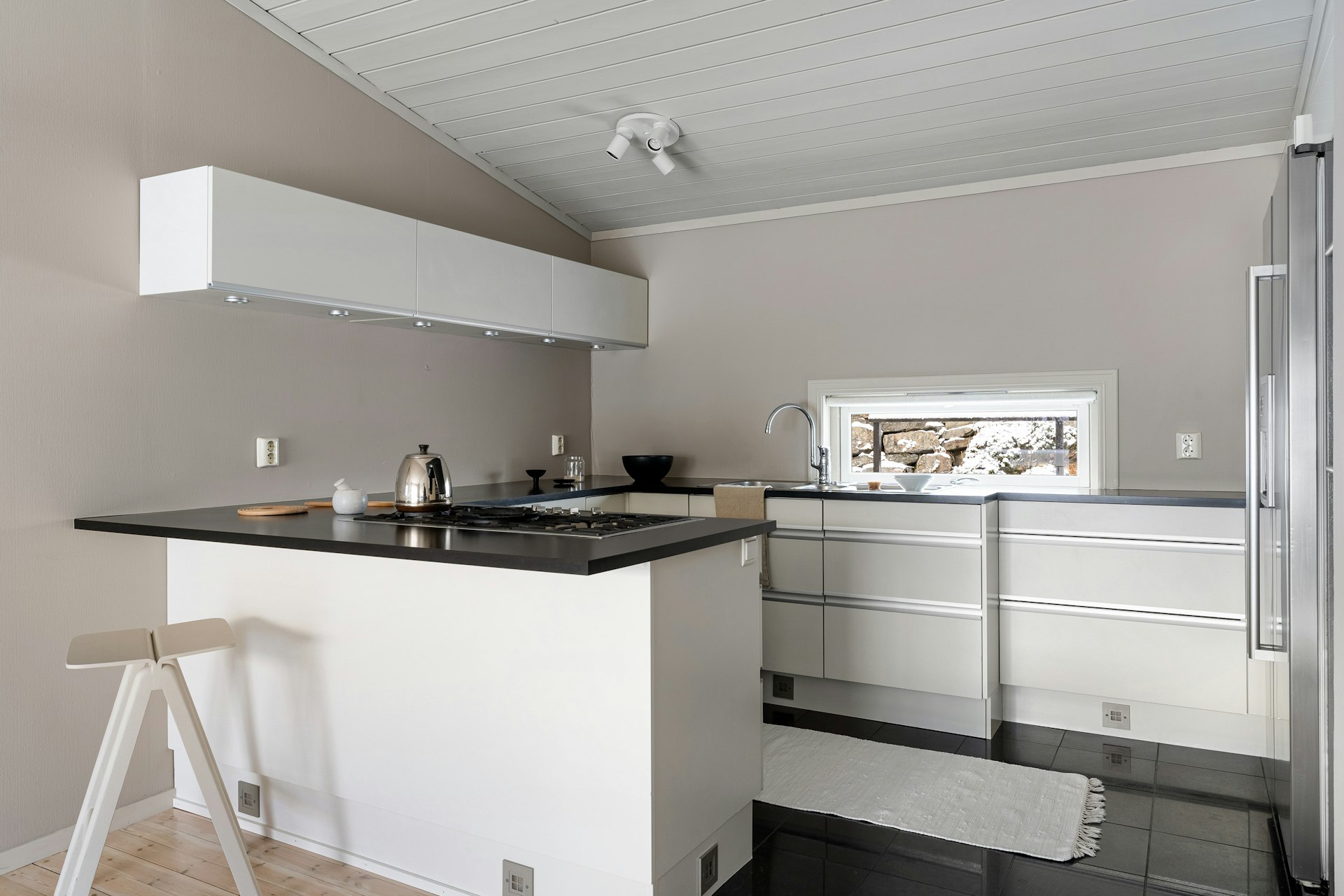 A white kitchen with a black counter top